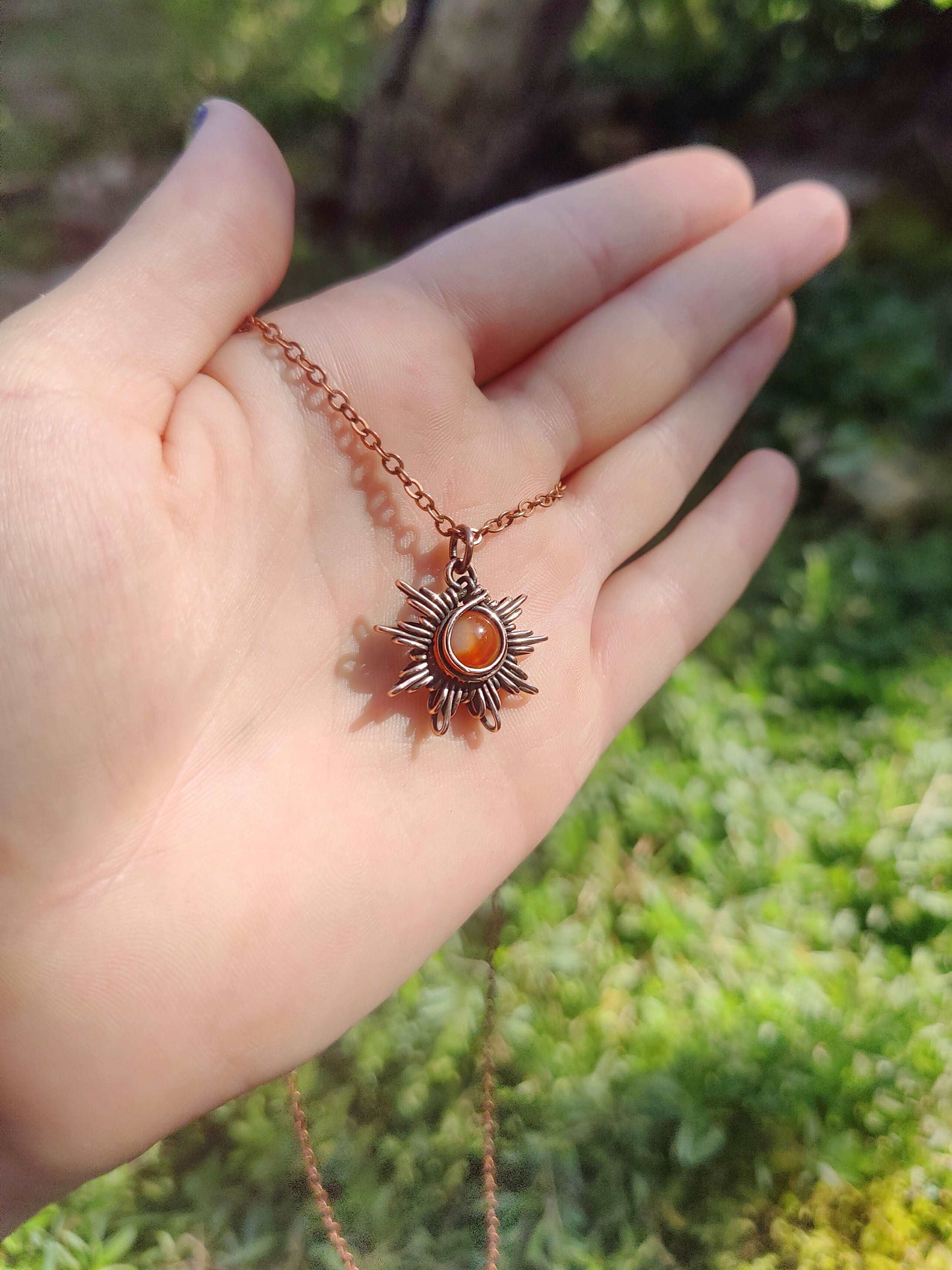 Handcrafted wire wrap carnelian sun necklace in antique copper. Versatile and perfect for any style.